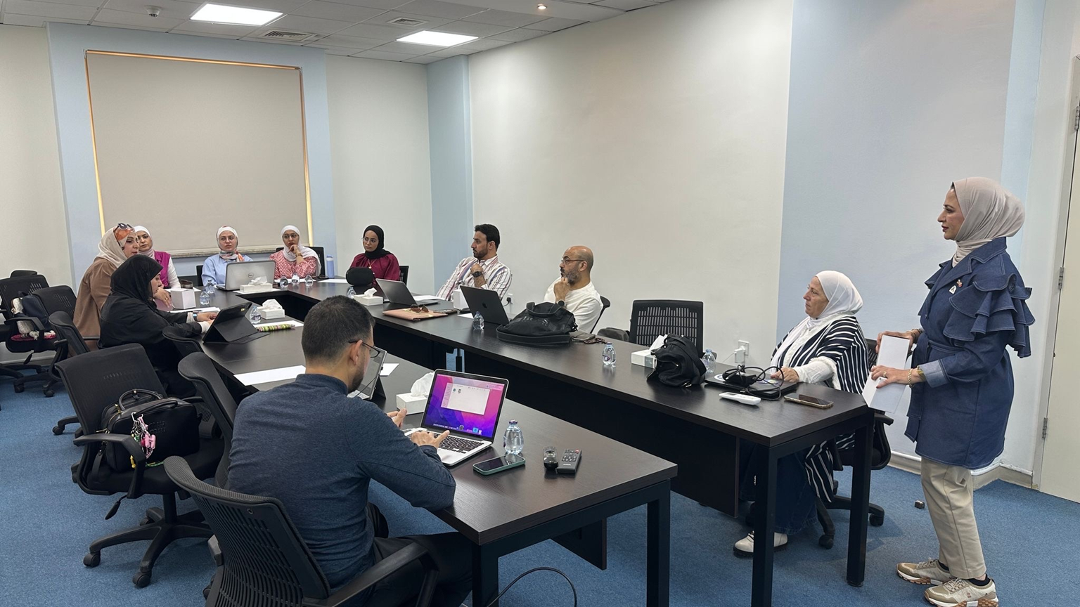 Men and women in Jordan sitting around tables with laptops in front of each one learning about the GLOBE website