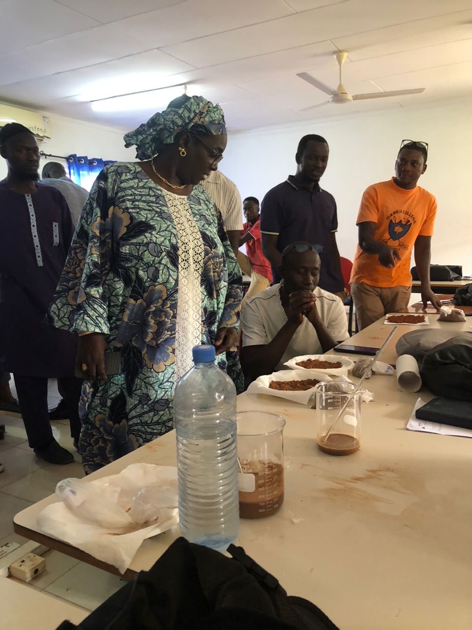 People inside with dirt samples and measurement tools.